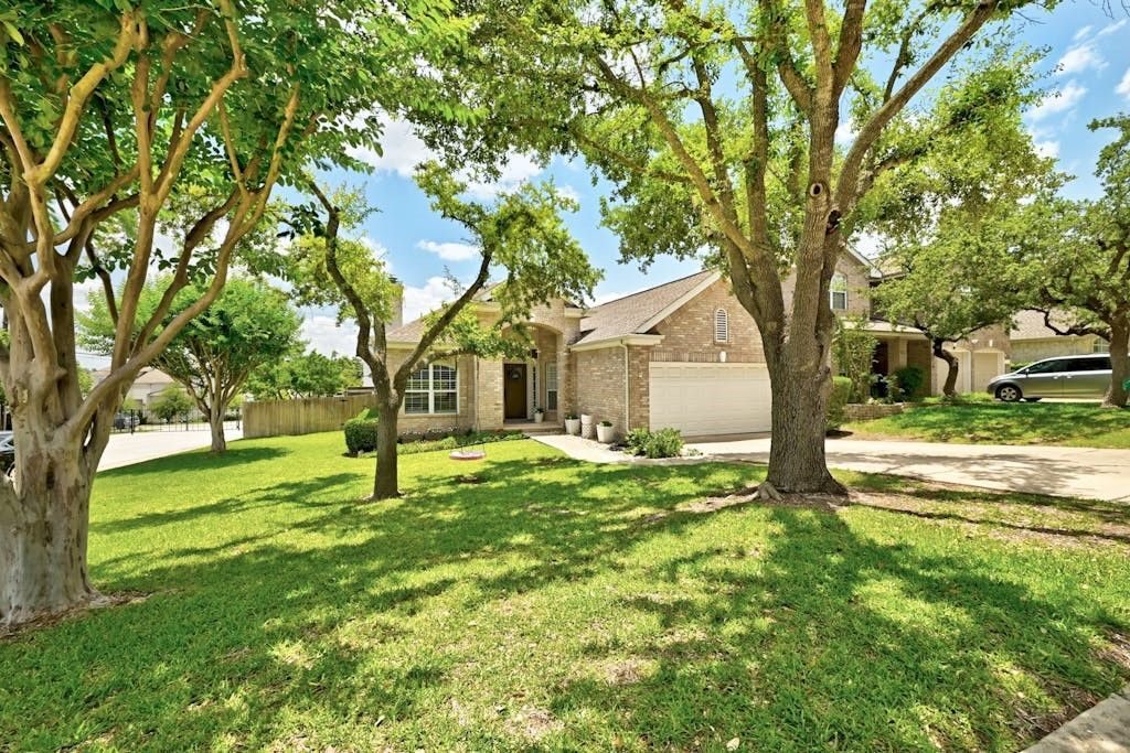 Central Texas family home exterior with mature oak trees