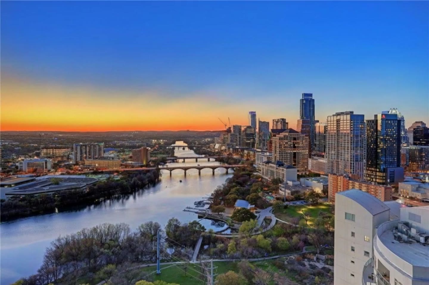 Aerial view of the Austin, Texas skyline at sunset over Lady Bird Lake.